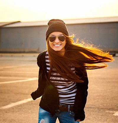 mujer pelo muy largo negro con gorro de invierno y gafas de sol